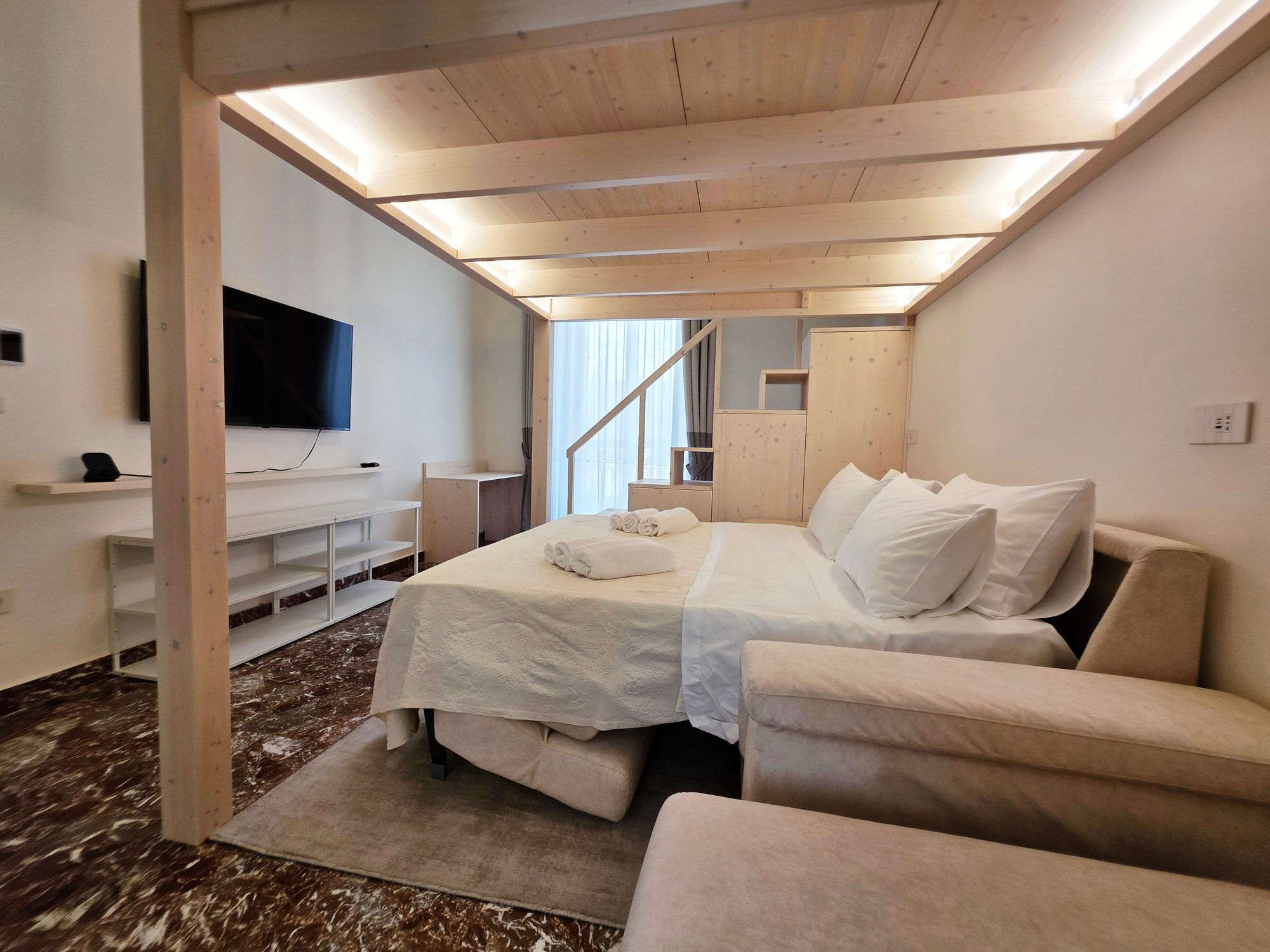 Divano letto aperto sotto le travi con luce LED
