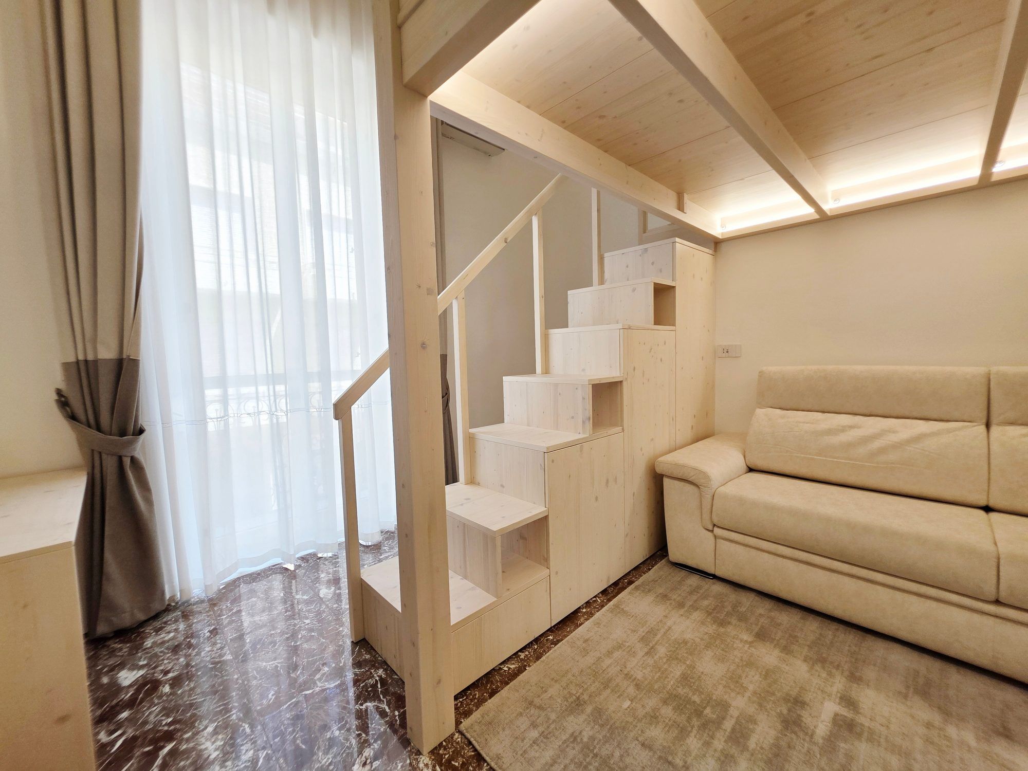 Divano e scala con la portafinestra sul balcone